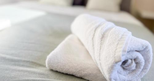 - une serviette blanche assise au-dessus du lit dans l'établissement AC - PRIVATE Exterior - Au pied du palais des papes!, à Avignon