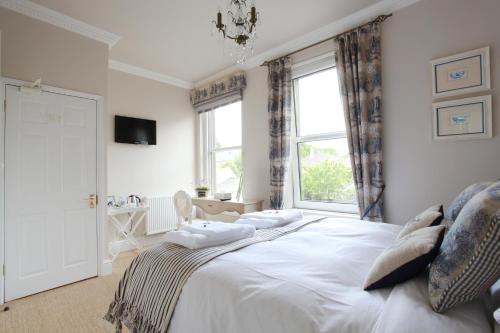Un dormitorio con una gran cama blanca y una ventana en Brindleys, en Bath