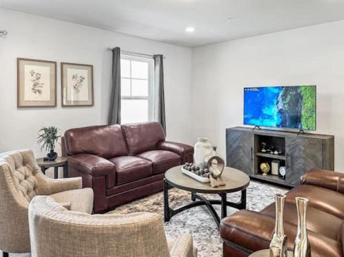 a living room with a couch and a tv at Luxurorious Townhome In Reading in Mount Penn