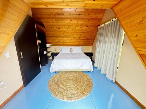 a bedroom with a bed and a rug on the floor at Pachakuti Eco-vida Hotel in Caicedonia