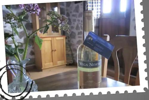 a bottle of wine on a table with a vase of flowers at Authentic country house Casa Gloria with fantastic views in Franceses