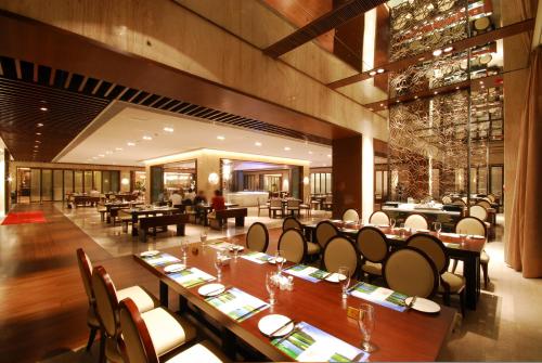 a restaurant with tables and chairs in a room at Mission Hills Hotel Resorts Dongguan in Dongguan