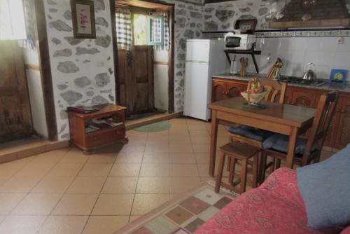 a kitchen with a table and a kitchen with a refrigerator at Authentic country house Casa Gloria with fantastic views in Franceses
