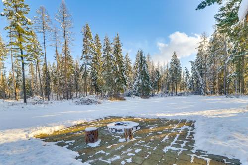 a bench in a snow covered field with trees at Columbia Falls Private Retreat Pool Table and Deck! in Columbia Falls