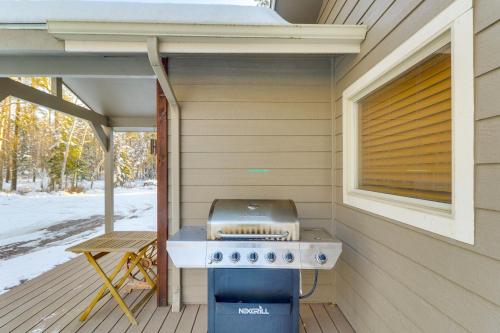 a grill on the porch of a tiny house at Columbia Falls Private Retreat Pool Table and Deck! in Columbia Falls