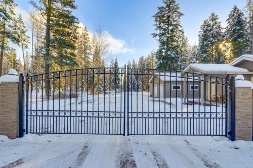 a gate in front of a house with snow on the ground at Columbia Falls Private Retreat Pool Table and Deck! in Columbia Falls