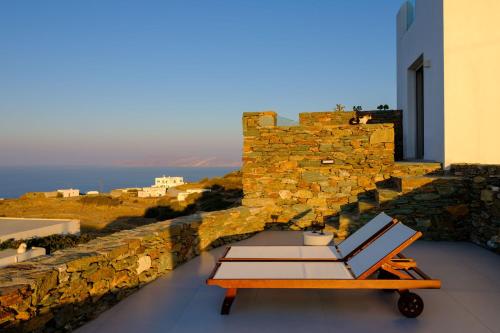 a room with a chair and a table and a building at Seascape Suites Folegandros in Ano Meria