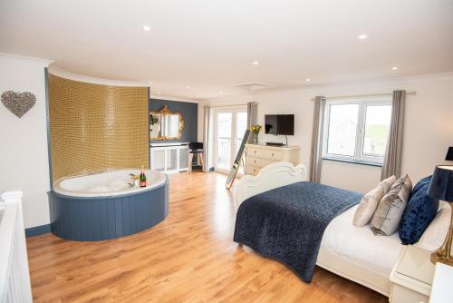 a bedroom with a tub and a bed in it at The Paddocks Cottage in Westward Ho