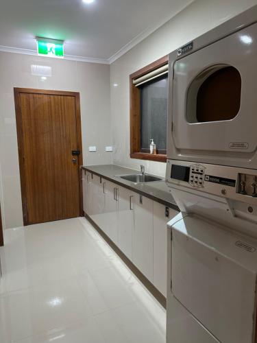 a kitchen with a microwave and a sink at Guest Room in Kealba in St Albans