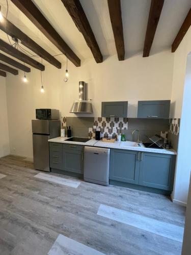 une grande cuisine avec des armoires et des appareils bleus dans l'établissement Maison 7 personnes TV connectée, à Joinville