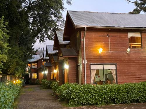 a row of wooden houses with lights on them at Cabañas Orillas del Lago in Pucón