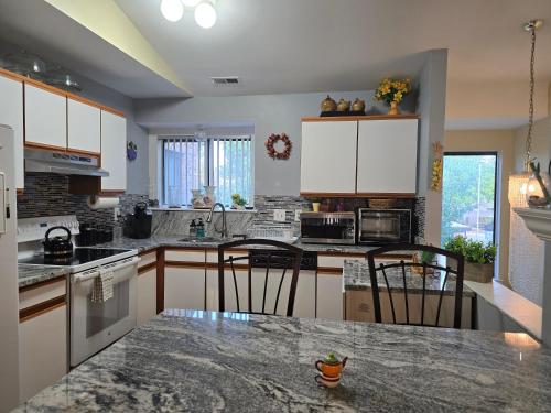 a kitchen with white cabinets and a granite counter top at Entire 2-bedroom, 2 bath home with parking and newly renovated floors in Canton