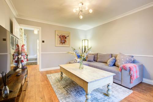 a living room with a couch and a coffee table at Clarence Cottage in Fleet