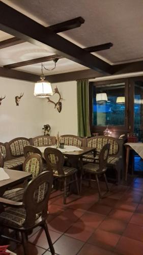 a dining room with tables and chairs and windows at Hotel-Restaurant Tannenhof in Ahrbrück