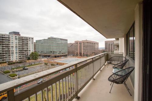 a balcony with two chairs and a view of a city at Prime Crystal City Location Apartment Near Airport in Arlington