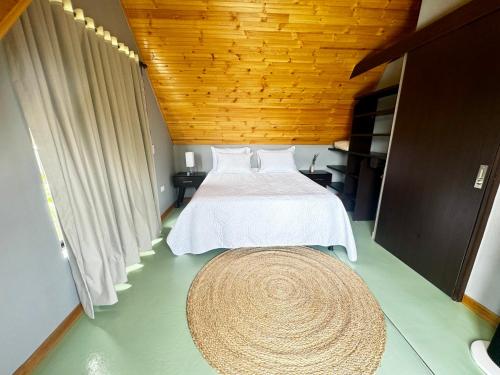 a bedroom with a white bed and a large rug at Pachakuti Eco-vida Hotel in Caicedonia
