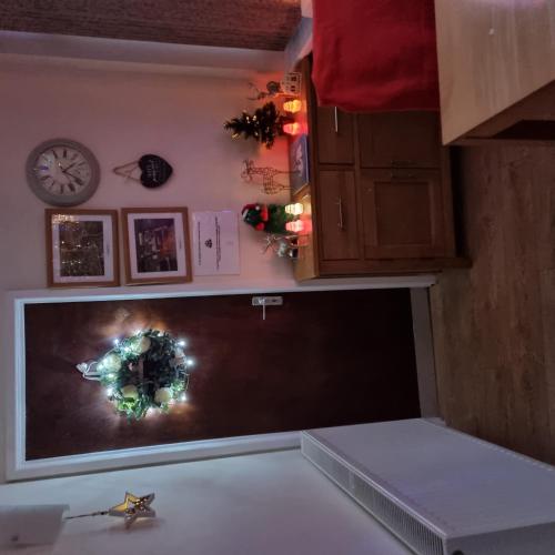 a room with a tv with a christmas wreath on the wall at Trevarrian Lodge in Newquay