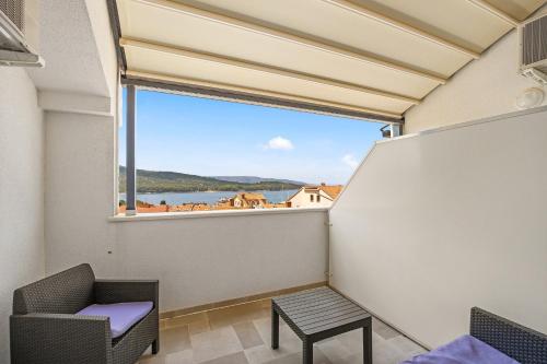 a room with a large window with a chair and a table at Apartments Jana & Paula in Cres