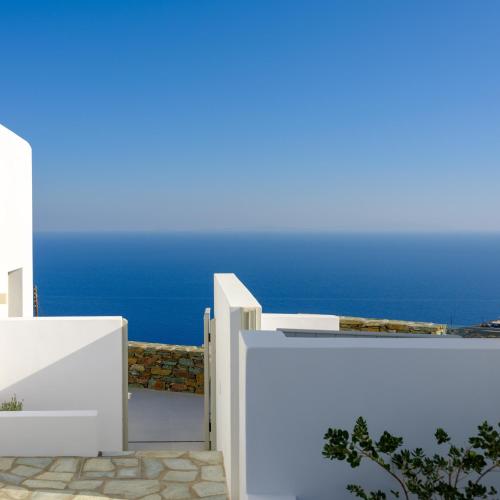 a white fence with the blue ocean in the background at Seascape Suites Folegandros in Ano Meria