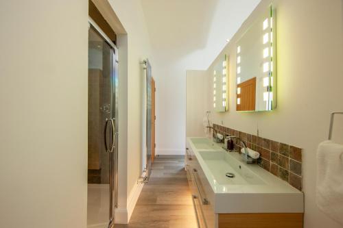 a bathroom with two sinks and a glass shower at Ardtorna in Benderloch