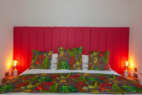 a bedroom with a large bed with a red headboard at Ardtorna in Benderloch