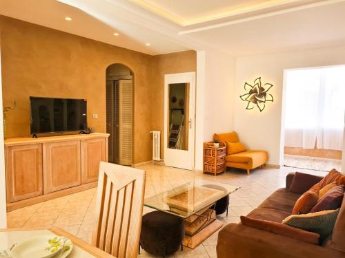 un salon avec un canapé et une télévision dans l'établissement Charmant appartement - Climatisation - Nice, à Nice