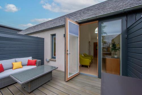 a balcony with a couch and a sliding glass door at Ardtorna in Benderloch