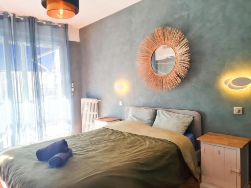 une chambre avec un grand lit et un miroir dans l'établissement Charmant appartement - Climatisation - Nice, à Nice