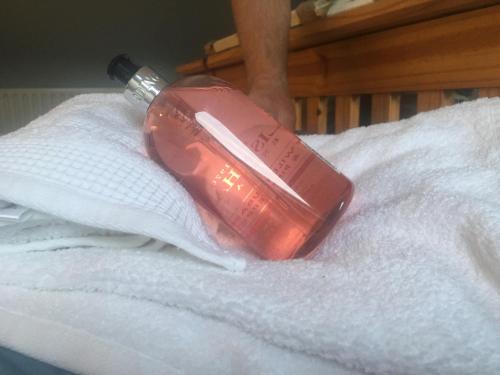 a red bottle sitting on top of a white towel at Driftwood Loft in Killyleagh