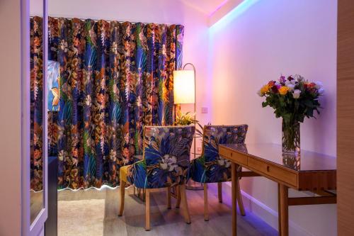 a dining room with a table and chairs and a curtain at Ardtorna in Benderloch