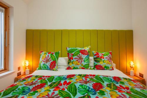 a bedroom with a large bed with colorful sheets and pillows at Ardtorna in Benderloch