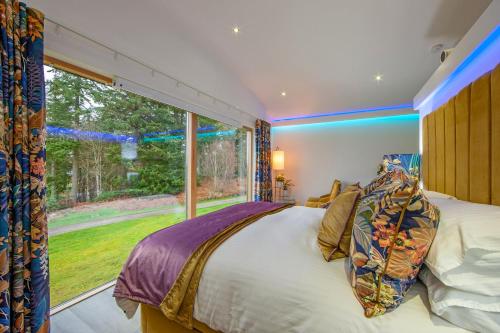 a bedroom with a bed and a large window at Ardtorna in Benderloch