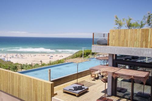a view of the beach from the balcony of a building at Noah Surf House Portugal in Santa Cruz
