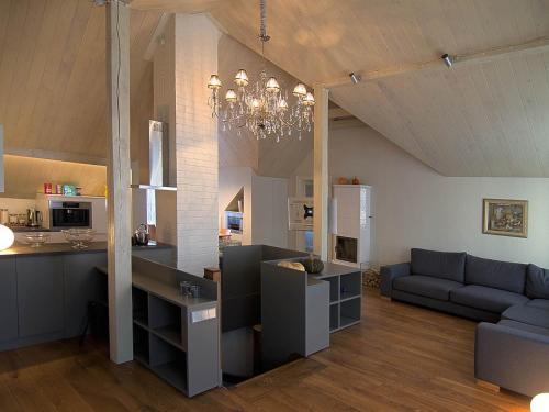 a kitchen and living room with a couch and a chandelier at Katrina Apartment in Kuldīga