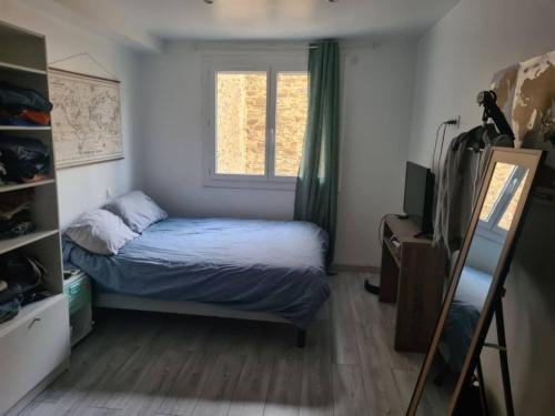 une petite chambre avec un lit et une fenêtre dans l'établissement Appartement refait neuf, proche du port, à Port-Vendres