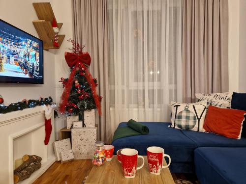 a living room with a christmas tree and a blue couch at Apartman MonTanja Kopaonik, u hotelu Kraljevi Čardaci in Kopaonik