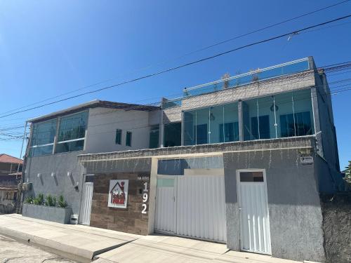 a gray building with a white garage at Loft Casa Feliz in Rio das Ostras