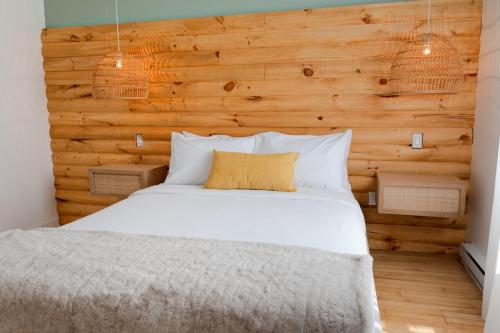 ein Schlafzimmer mit einem weißen Bett und einer Holzwand in der Unterkunft #10 - Serene Studio - Self Check in - Plateau - St-Denis - AC - TV in Montreal