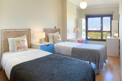 a bedroom with two beds and a window at Spacious 2BR apartment with free parking in Lisbon by Soulplaces in Lisbon