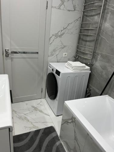 a bathroom with a washing machine in a shower at 1008 Apartment с living Кишинев Центр in Chişinău