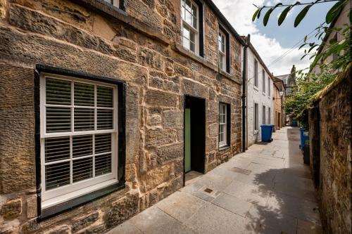 a brick building with a window on a street at 11 Crails Lane in St. Andrews