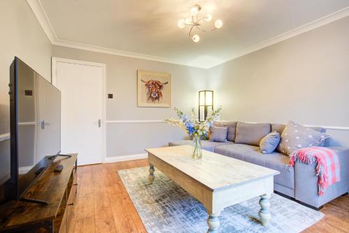 a living room with a couch and a table at Clarence Cottage in Fleet