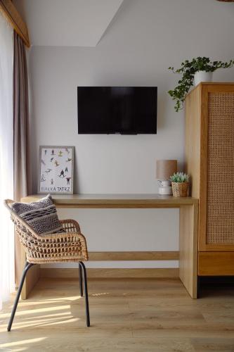 a living room with a television and a chair at Ciwersówka Domki Białka Tatrzańska in Białka Tatrzanska