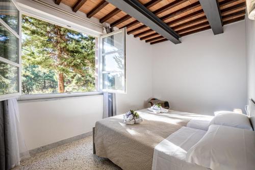 a bedroom with two beds and a large window at La Ripadoro Le Corti di Rivalto in Rivalto