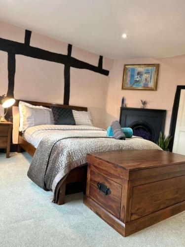 a bedroom with a large bed with a wooden headboard at 2BDR Cottage By Guest Nest Management In Horsham With Free Parking in Horsham