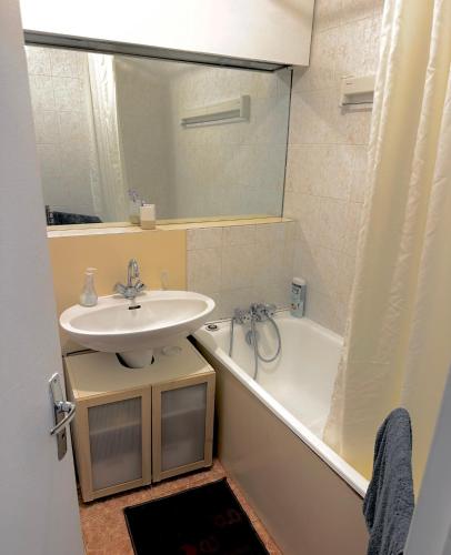 une salle de bain avec un lavabo, une baignoire et un miroir dans l'établissement Amazing Studio Paris La Défense, à Courbevoie