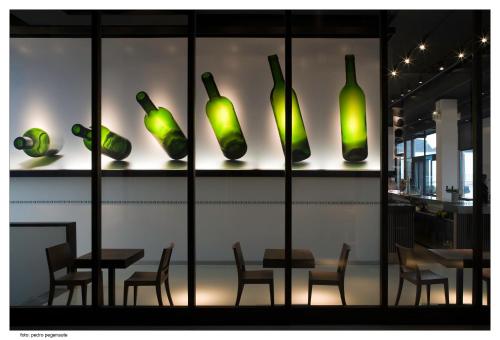 a group of green glass bottles on display in a restaurant at ETH Rioja in Haro