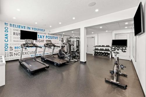 a gym with several treadmills and machines in it at Best Western Plus Airdrie Gateway in Airdrie