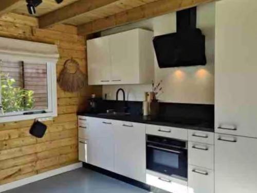 a kitchen with white cabinets and a stove top oven at Oak Valley 15 in Ons Belang