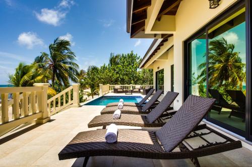a balcony with chairs and a swimming pool at Naïa Resort and Spa in Placencia Village